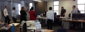 Equinox IT development team holding a daily standup with renovations in the background